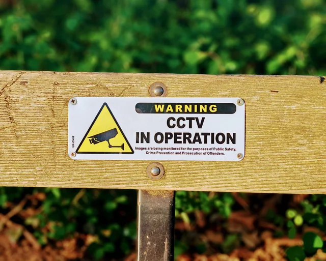 Wooden bench with a CCTV in operation warning sign, emphasizing public safety. Five demand signals for privacy first measurement, read from regulator and platform records