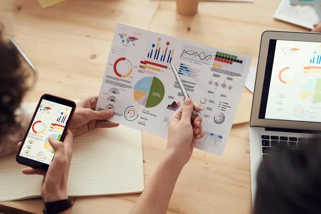 Team members analyze charts during a business meeting with laptops and smartphones. Server-side tracking under UK GDPR: a marketer's compliance checklist